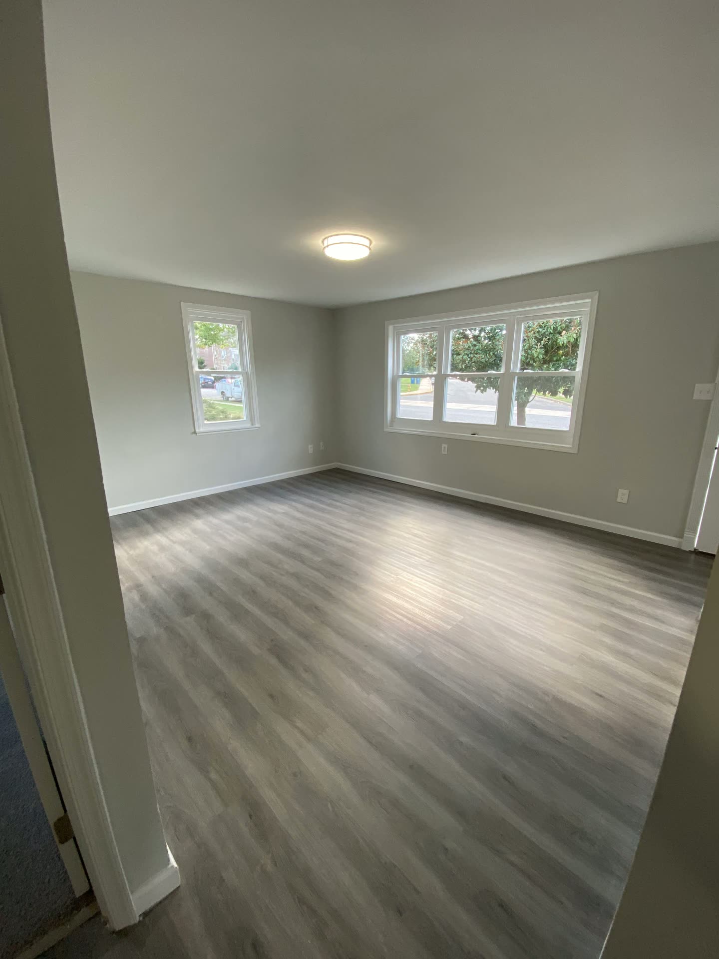 Habitación con piso nuevo tipo madera y ventanas amplias